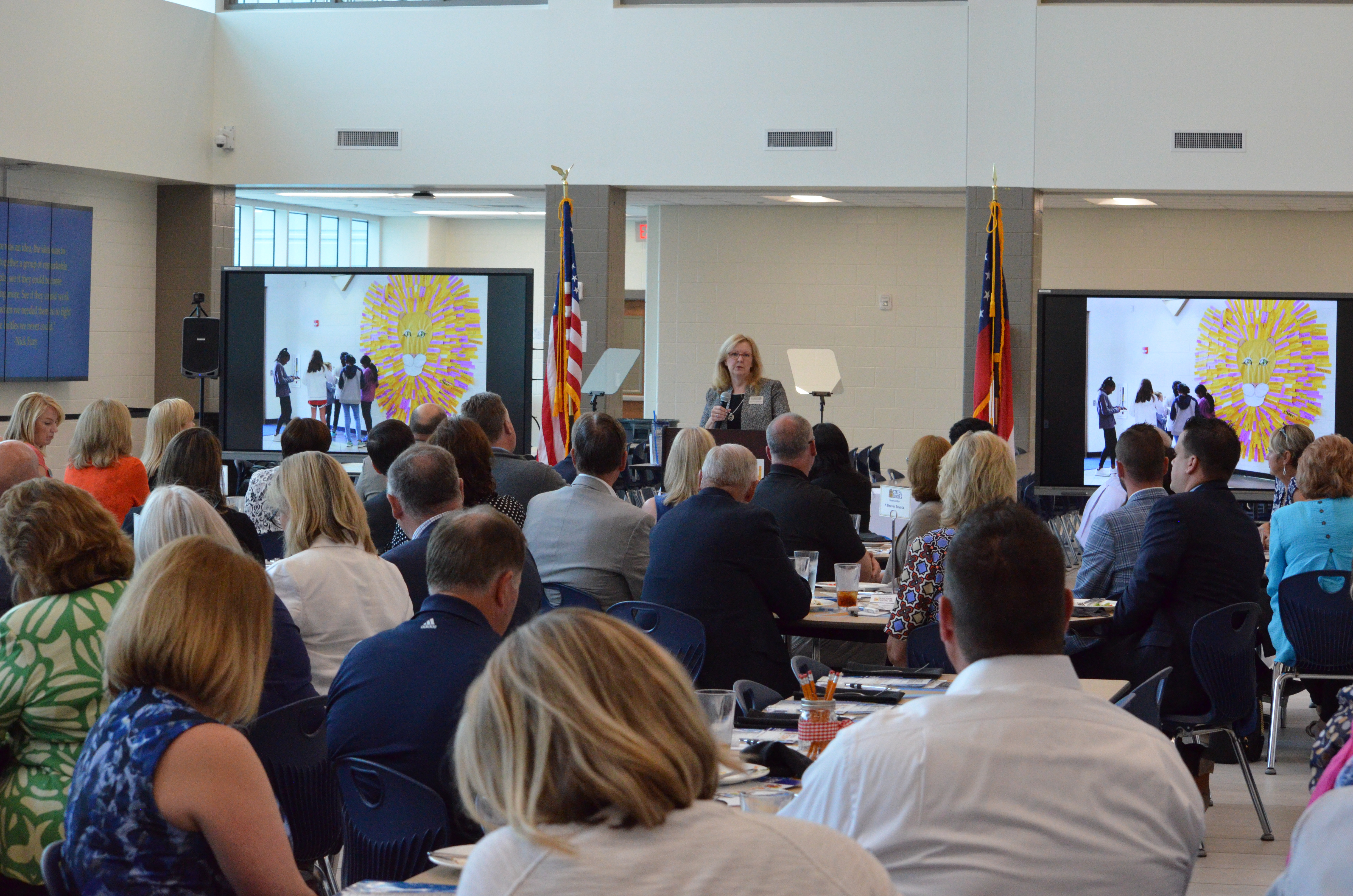 Attendees of State of the Schools listen to Kristen Morrssey present on the school year.