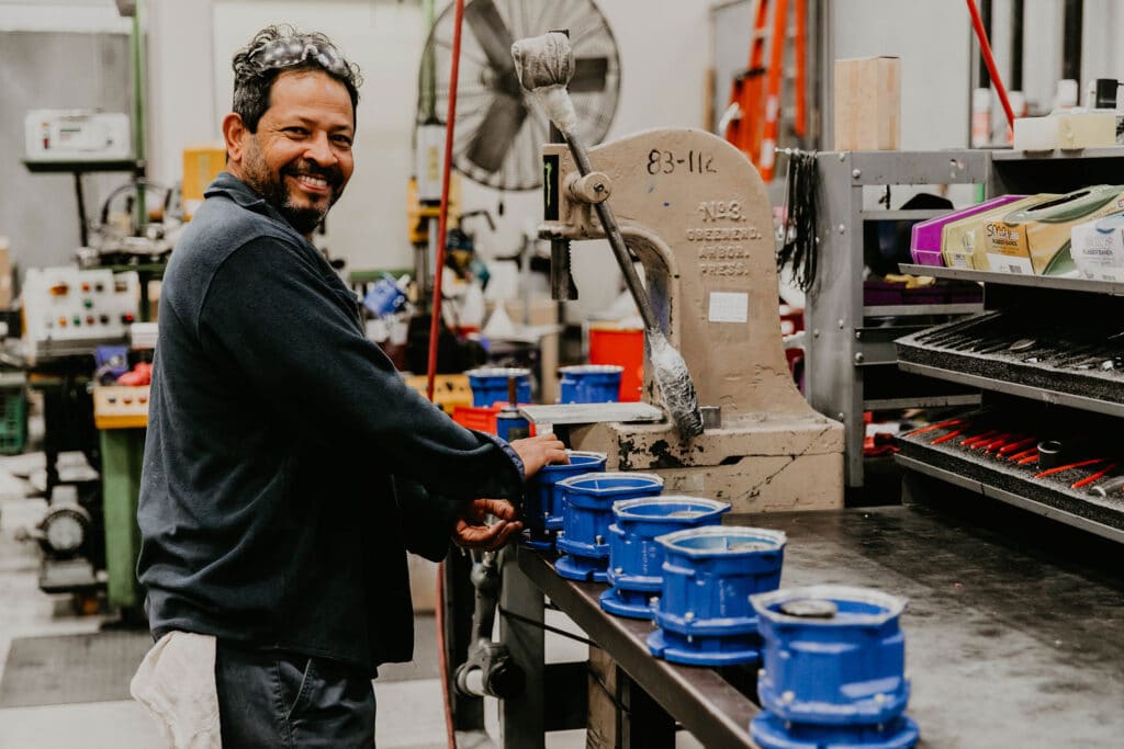 Man working in machine shop smiling at camera