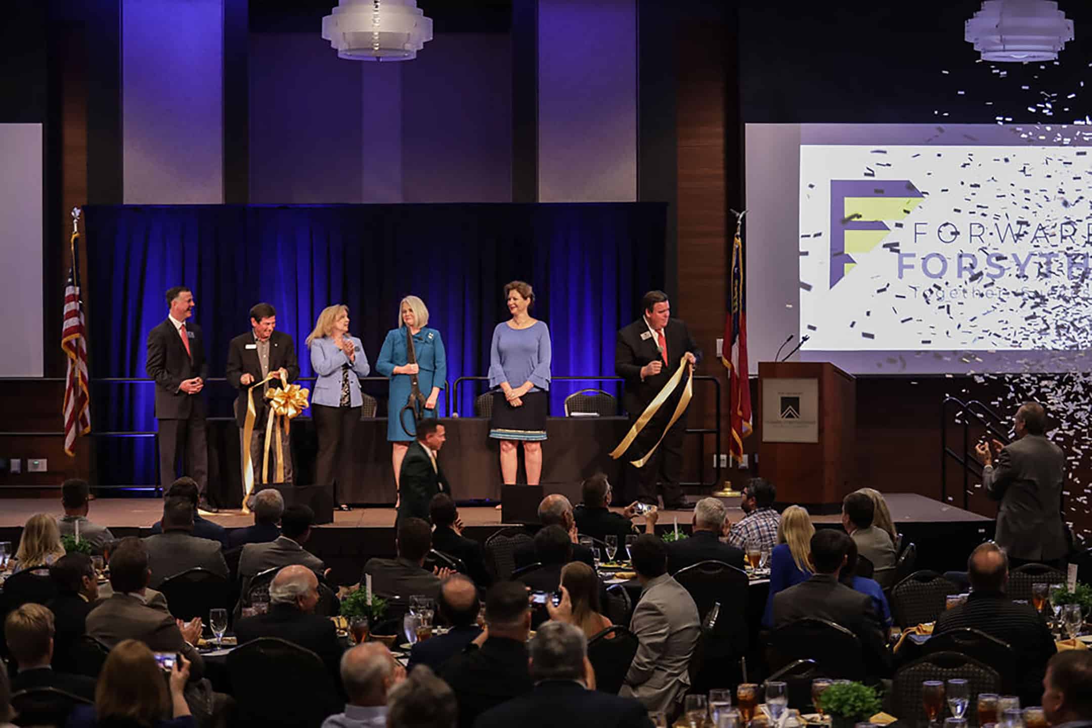People on stage at Forward Forsyth ribbon cutting ceremony